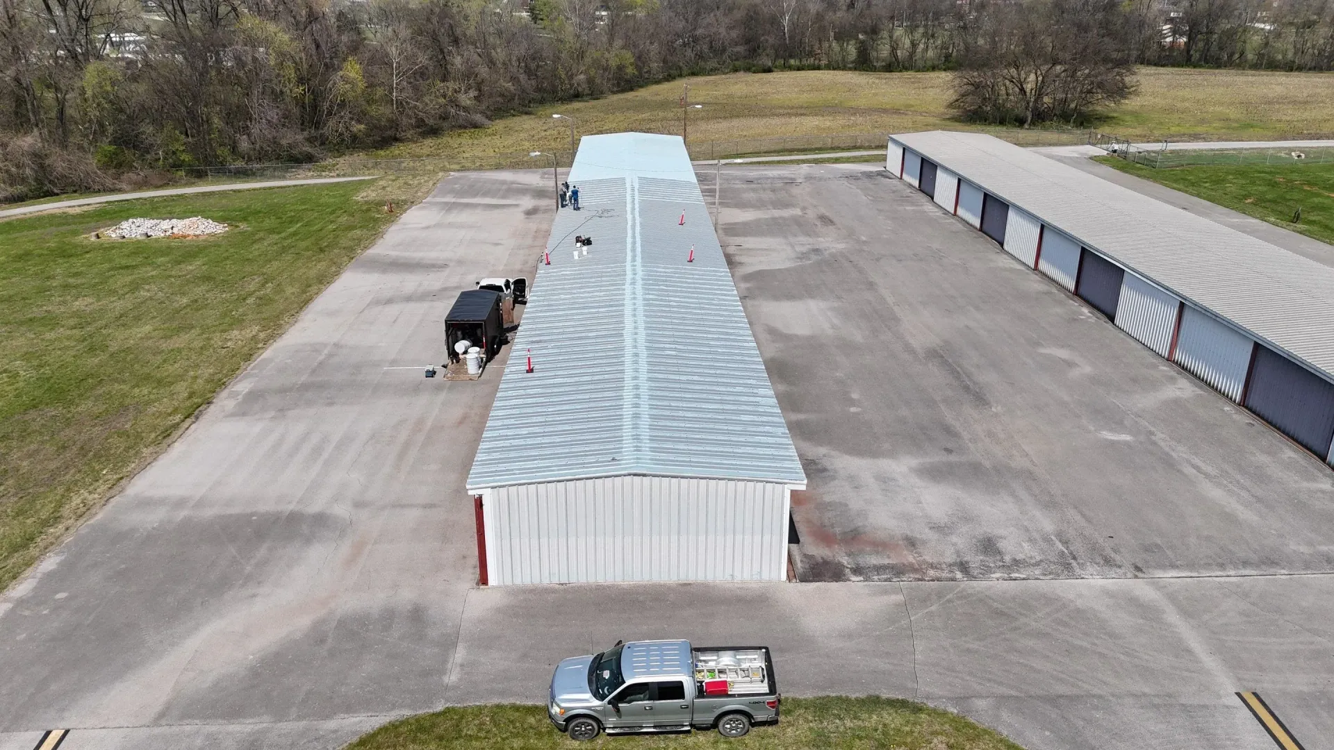 Aerial view of base coat being applied to a section of the metal roof during restoration in Hopkinsville, Kentucky