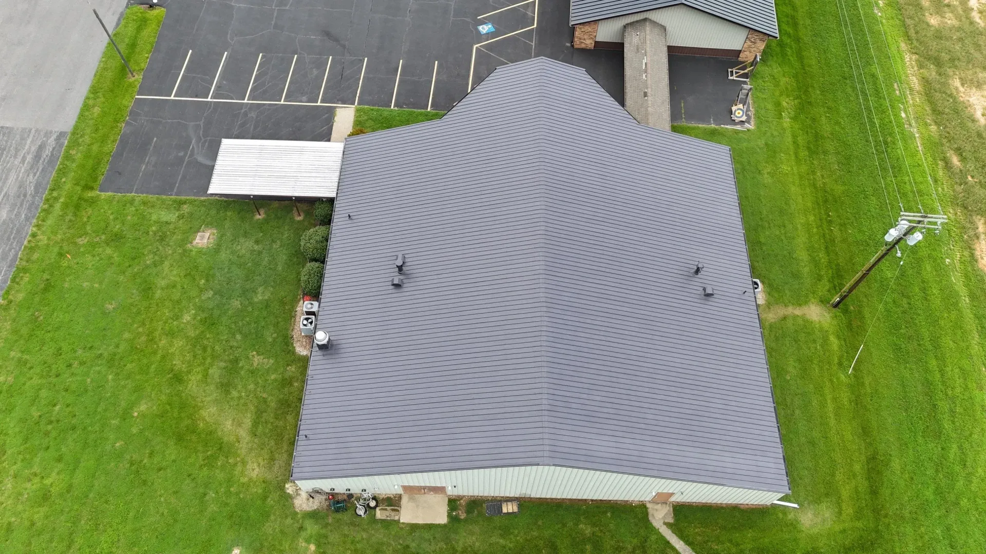 Aerial view of completed church metal roof restoration with reflective coating in Madisonville, Kentucky