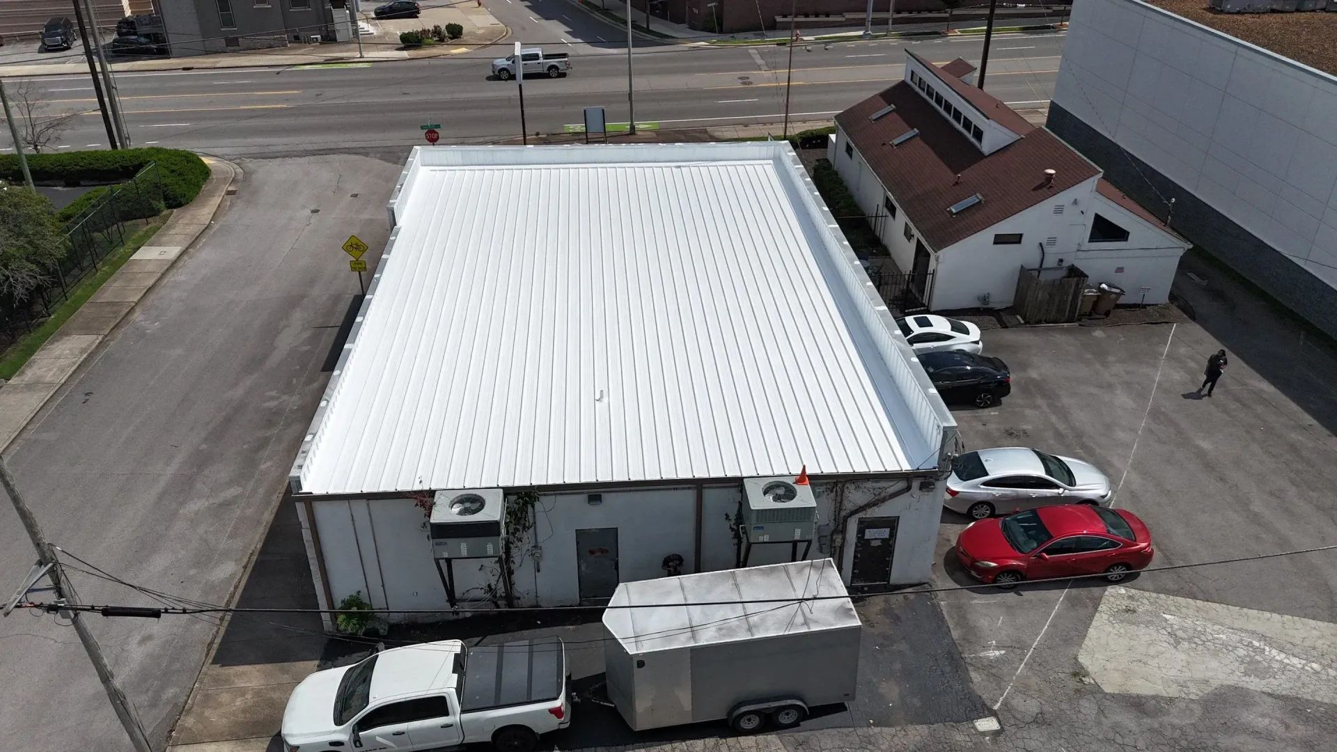Aerial view of completed metal roof restoration with white reflective coating in Nashville, Tennessee