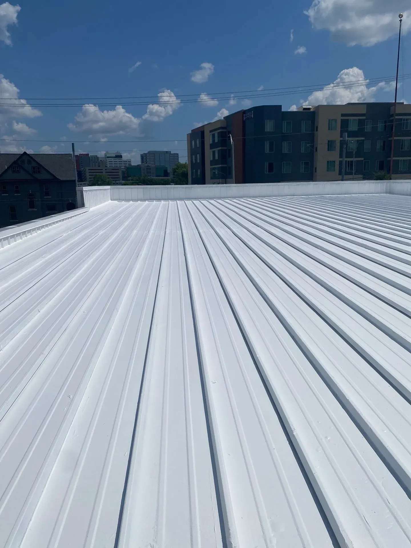 Close-up view of completed white reflective metal roof coating