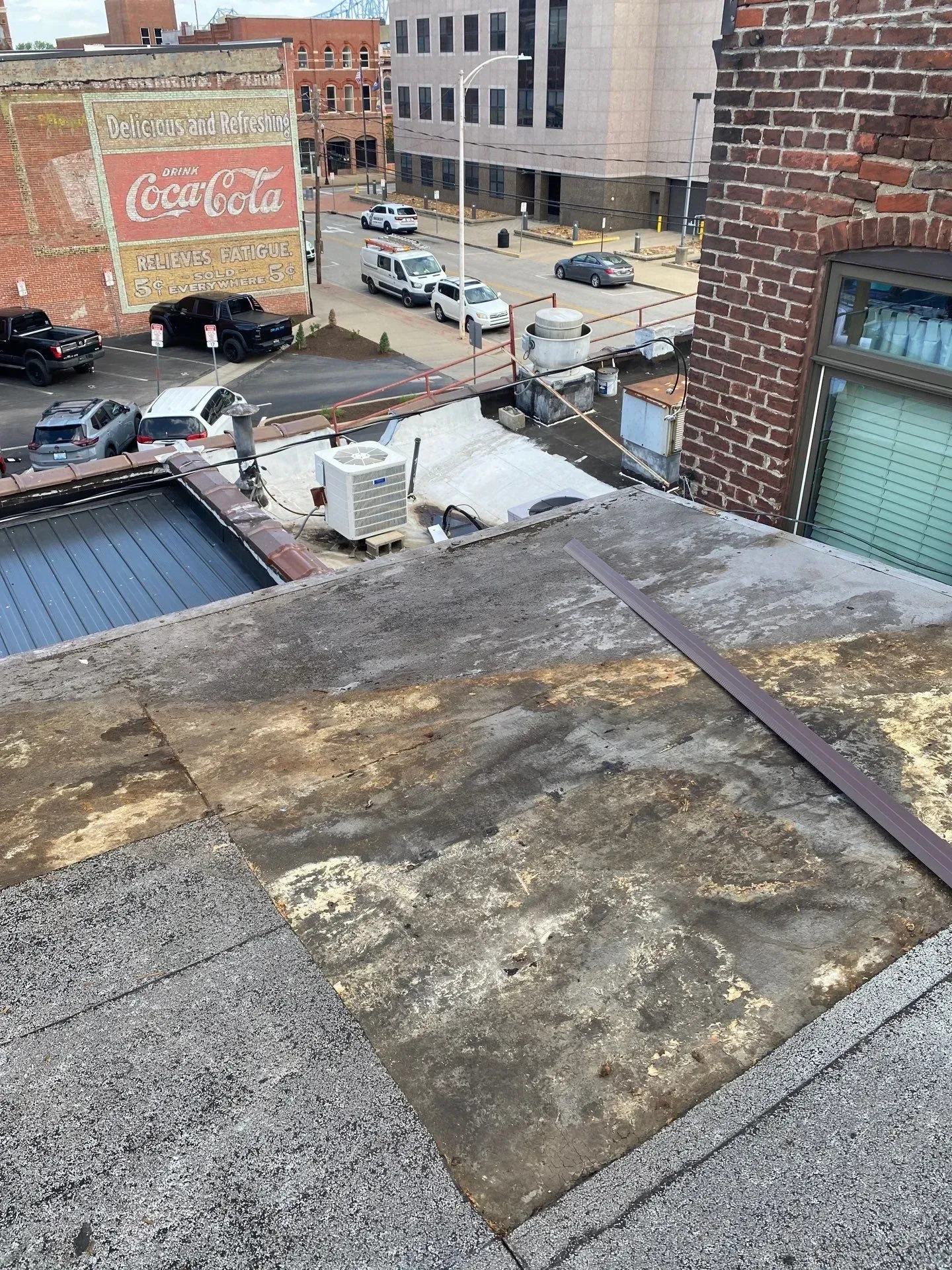 Close-up of worn gravel-surfaced roof material before tear-off in downtown Owensboro, Kentucky