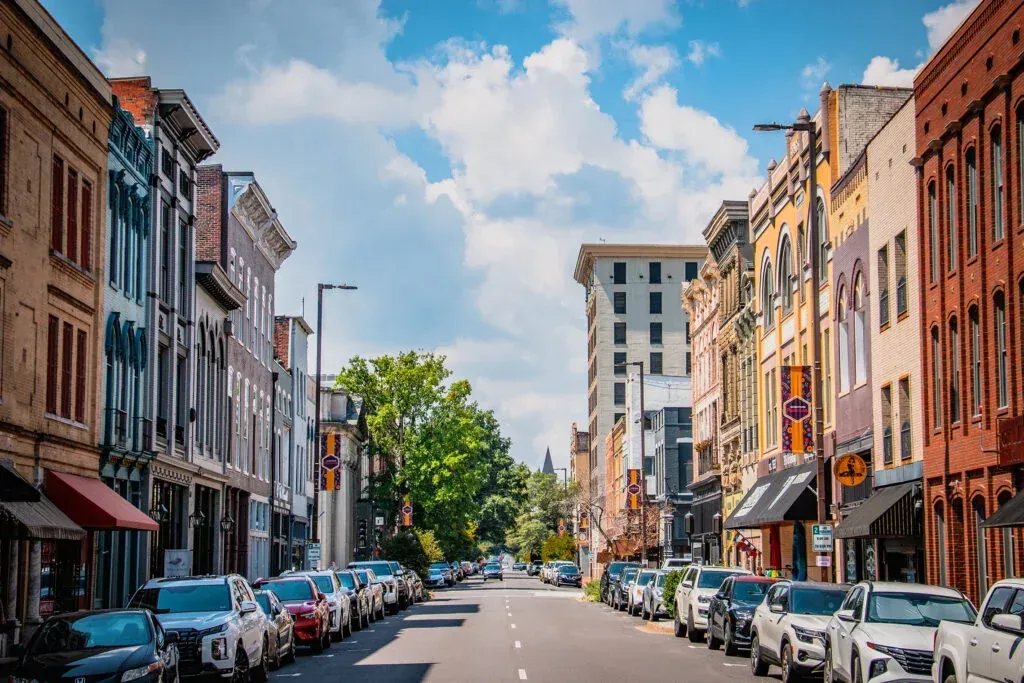Historic multi-story brick and stone buildings lining downtown Broadway/Main Street in Paducah, Kentucky, with parked cars along the street