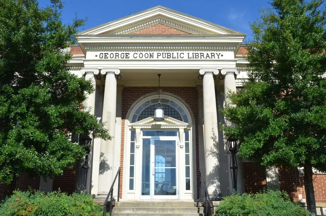 George Coon Public Library entrance in Princeton, Kentucky, with brick facade and white Ionic column portico