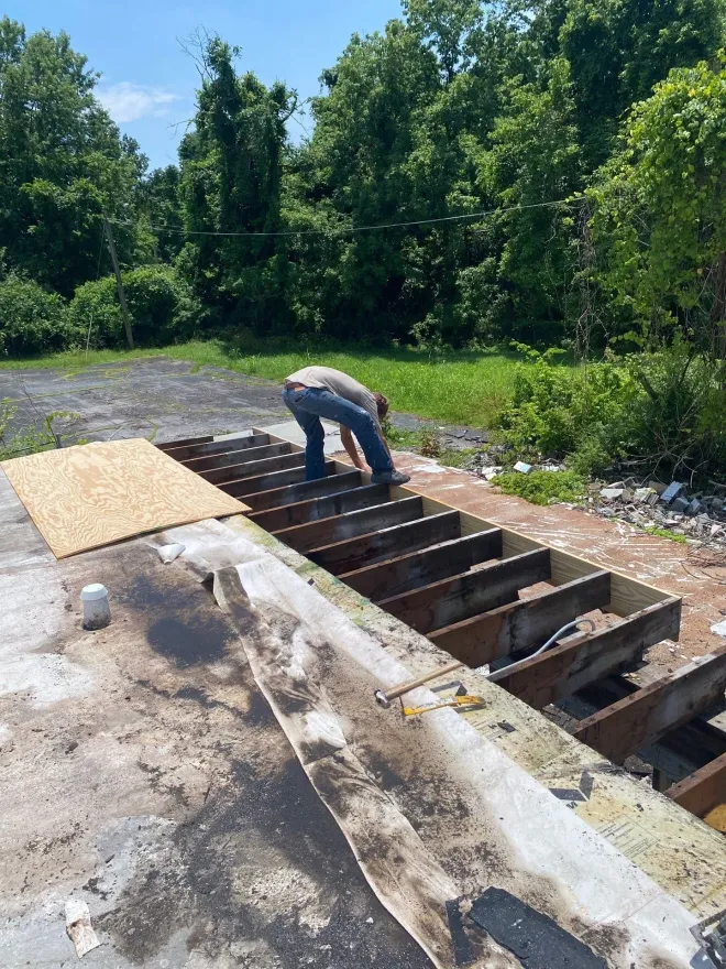 Exposed roof deck and joists during a commercial roof replacement tear-off