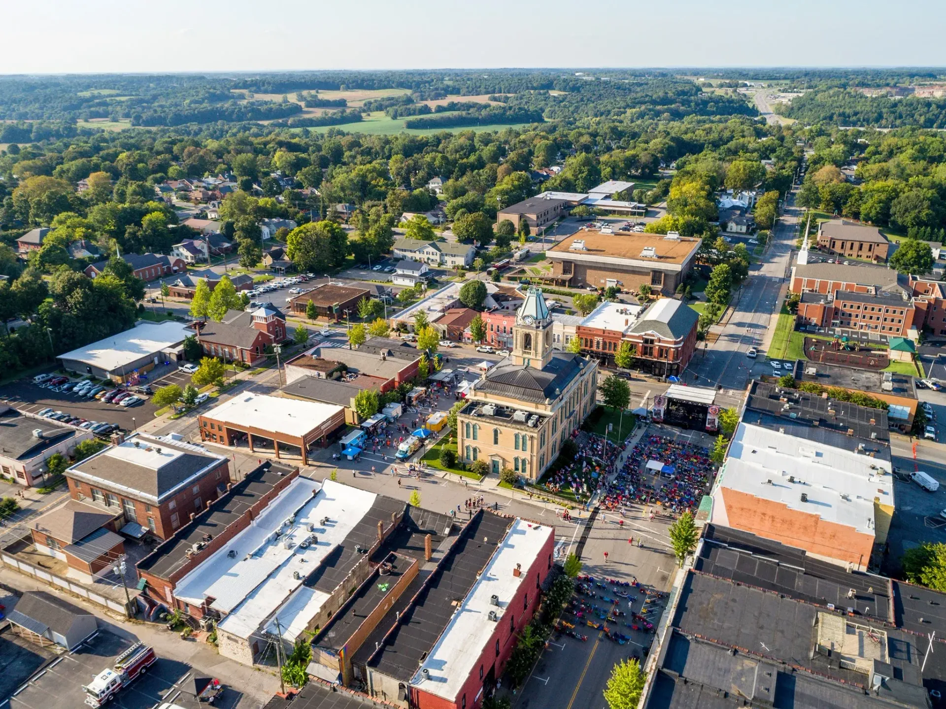 Aerial view of downtown Springfield, Tennessee, showing the Robertson County Courthouse clock tower and a street festival with crowds and food trucks