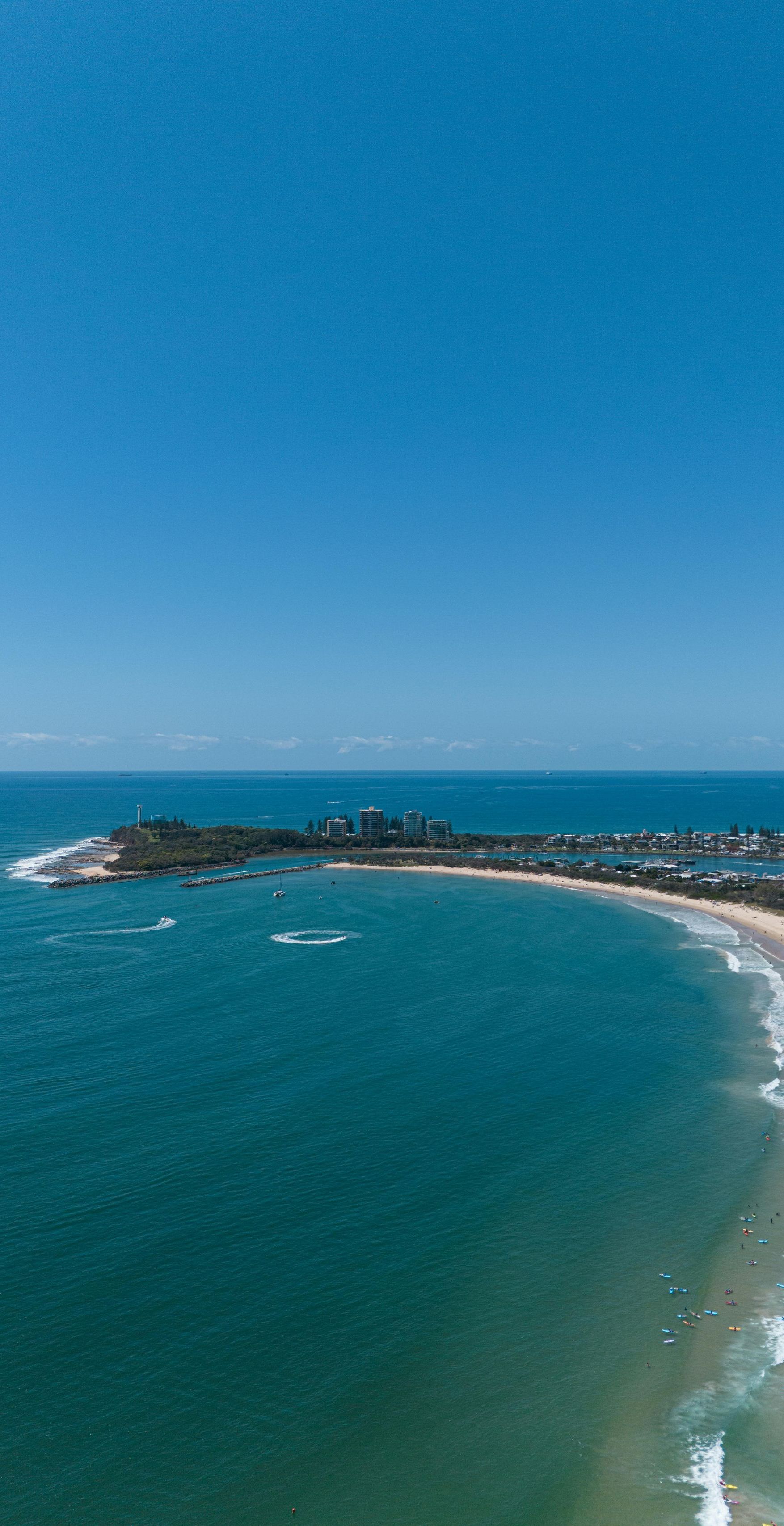 An aerial view of a beach and ocean on a sunny day.