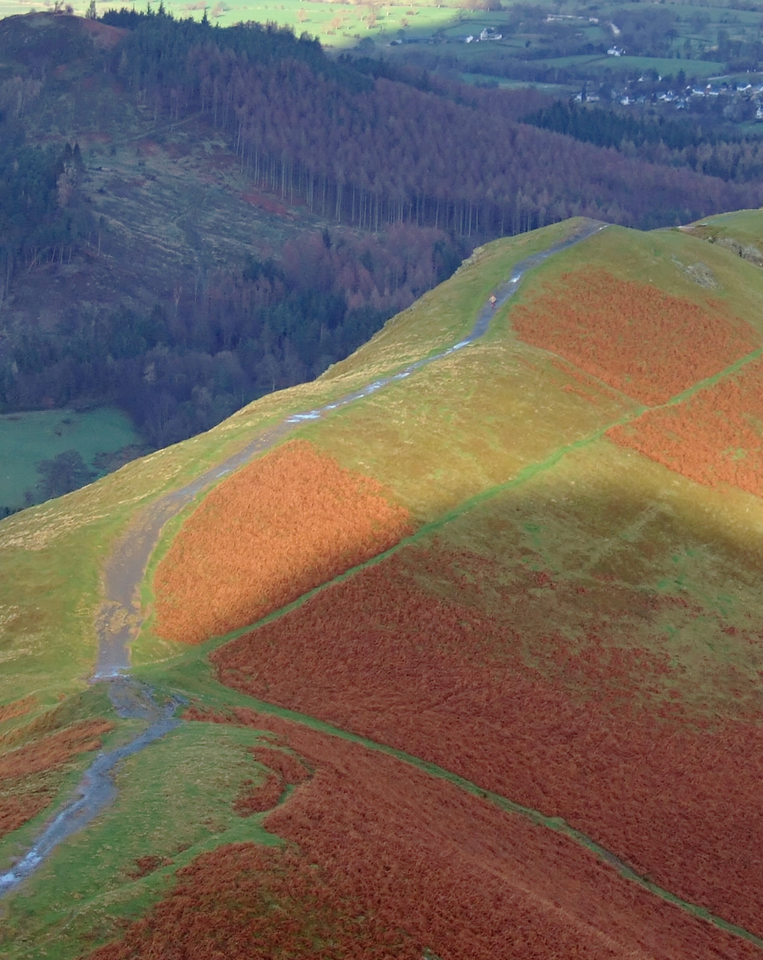 An aerial view of a hill with a road going up it.