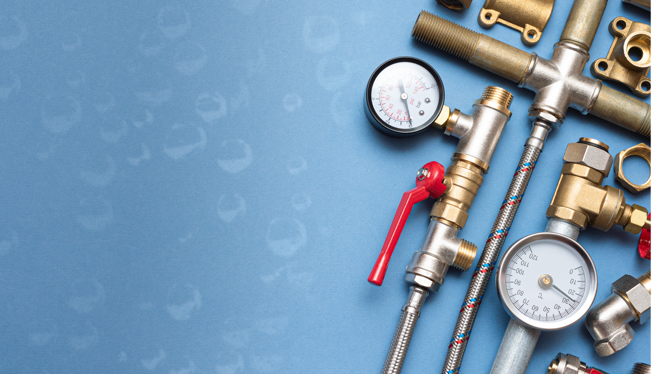 A bunch of plumbing pipes and gauges on a blue surface.
