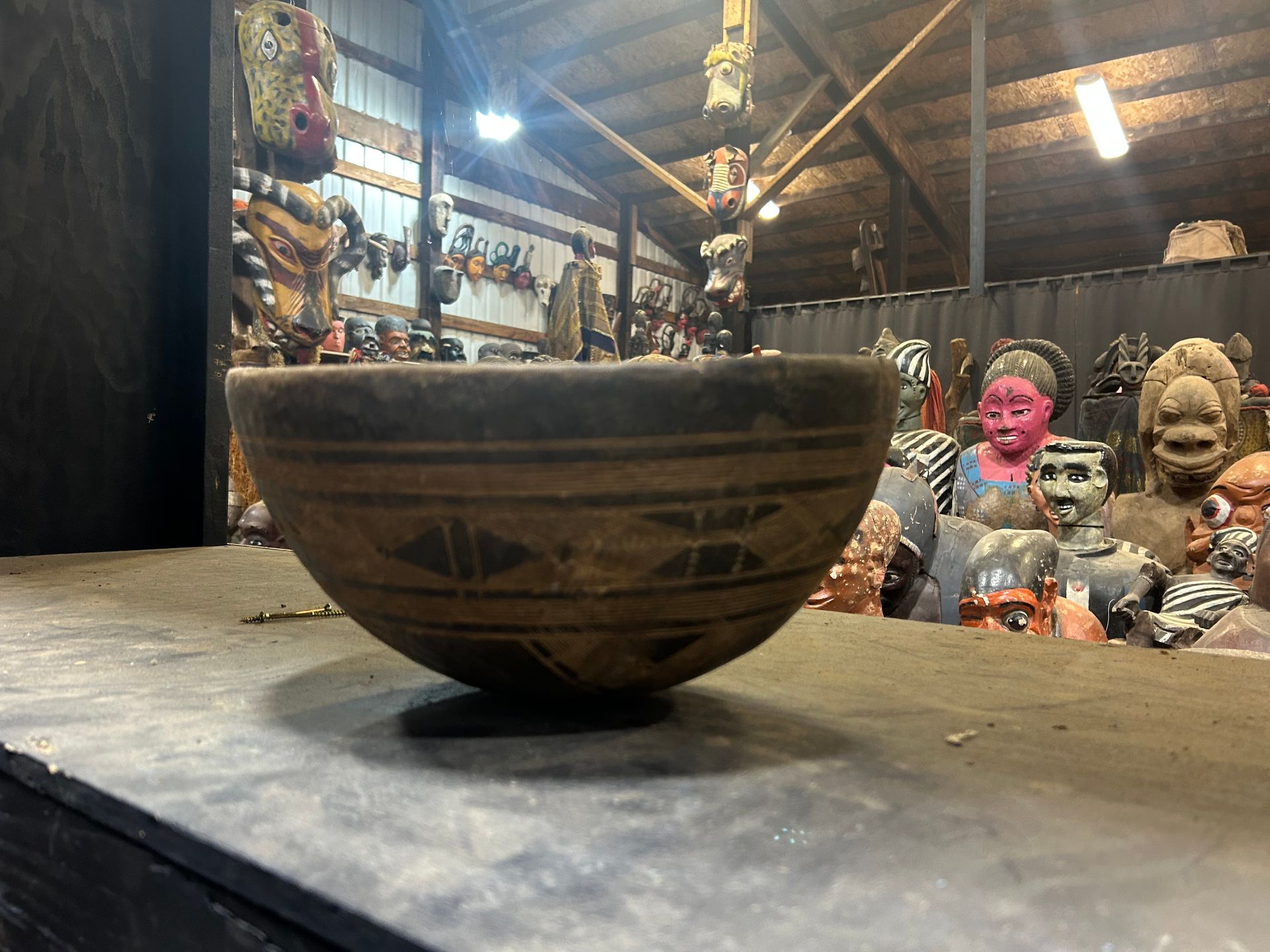 Handmade patterned ceramic bowl on a wooden table in a rustic craft shop