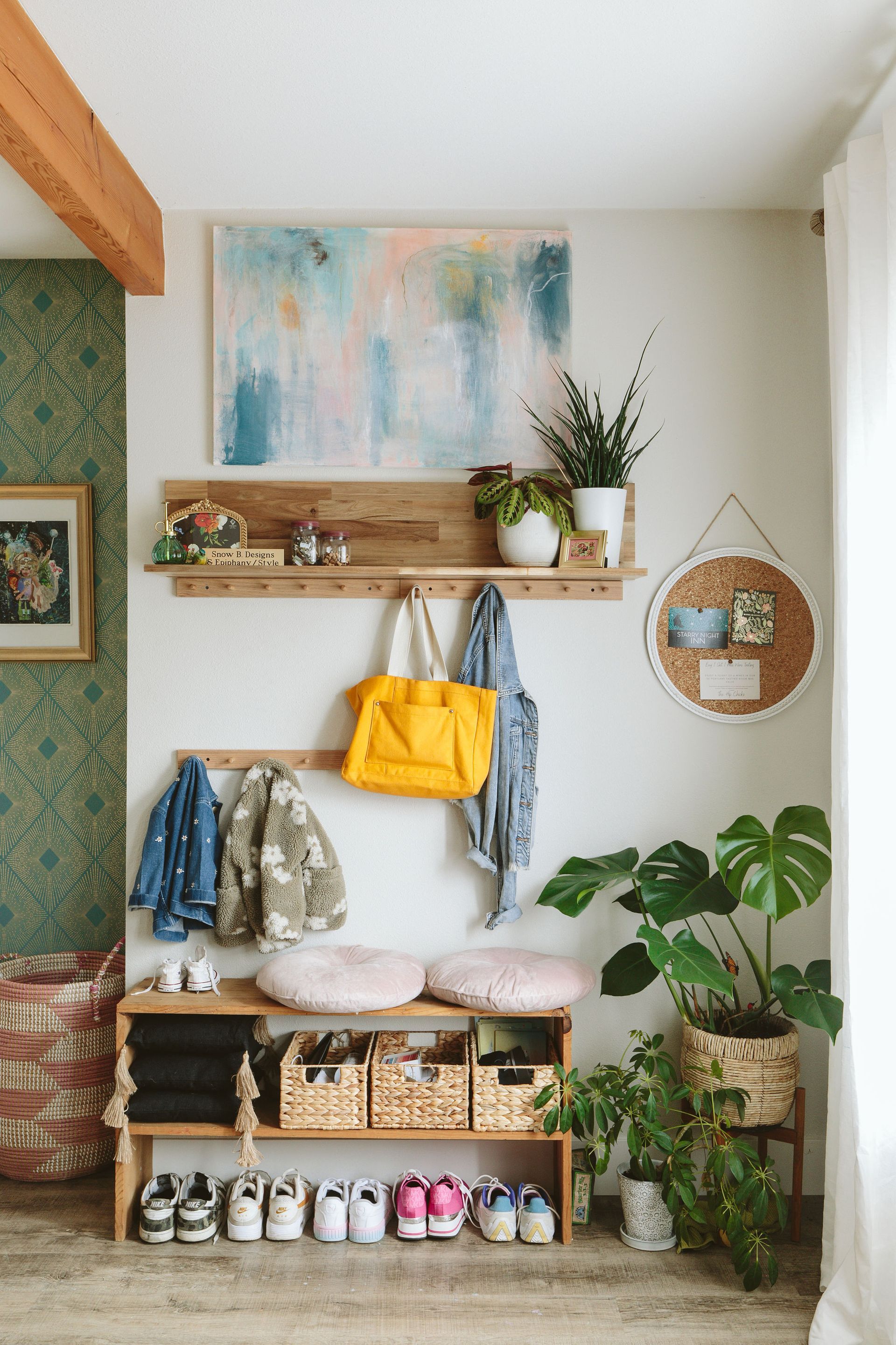 Cozy entryway with wall shelves, hanging plants, a bright yellow bag, bench, and shoe storage