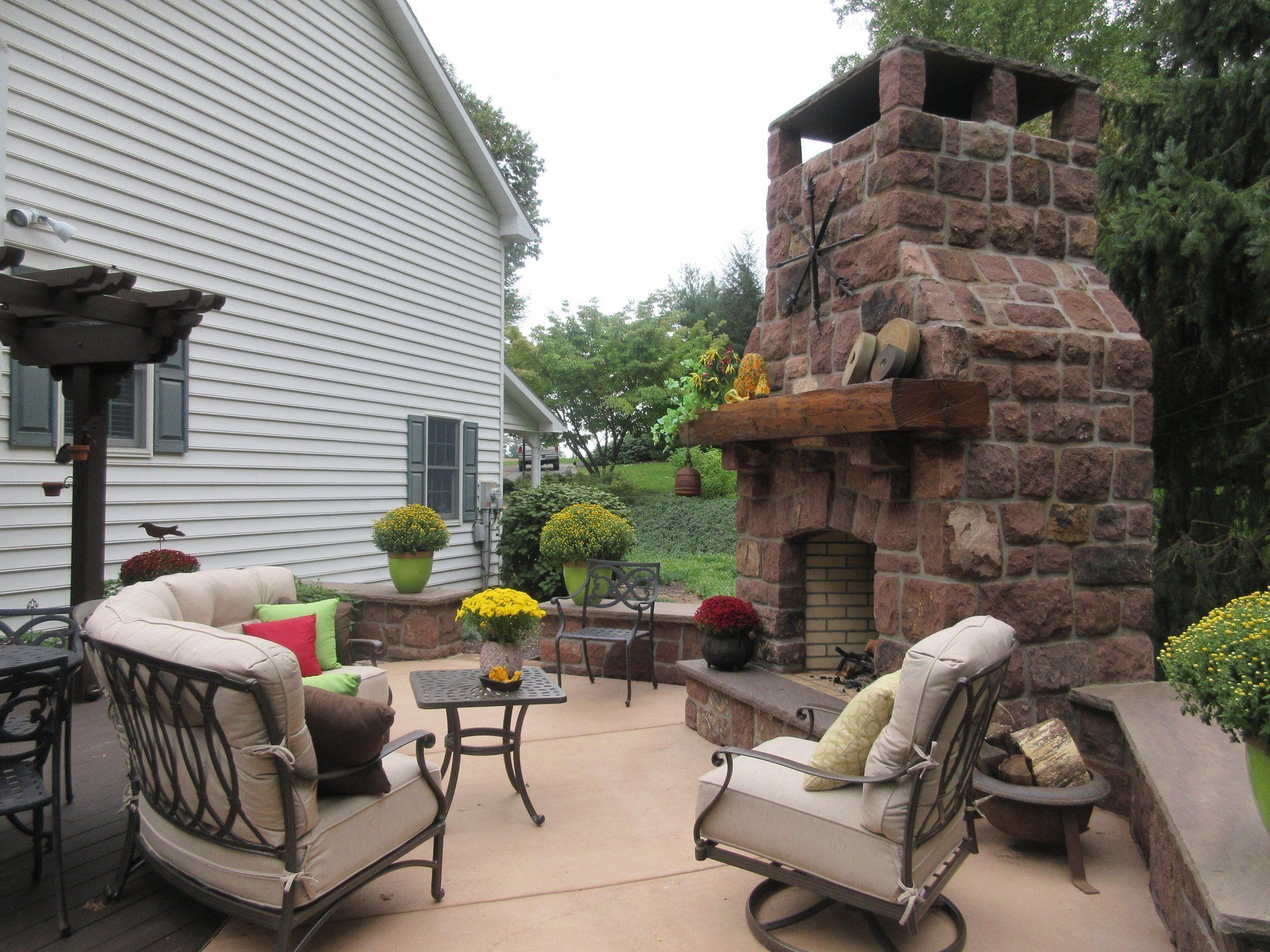 A patio with a fireplace and a couch and chairs