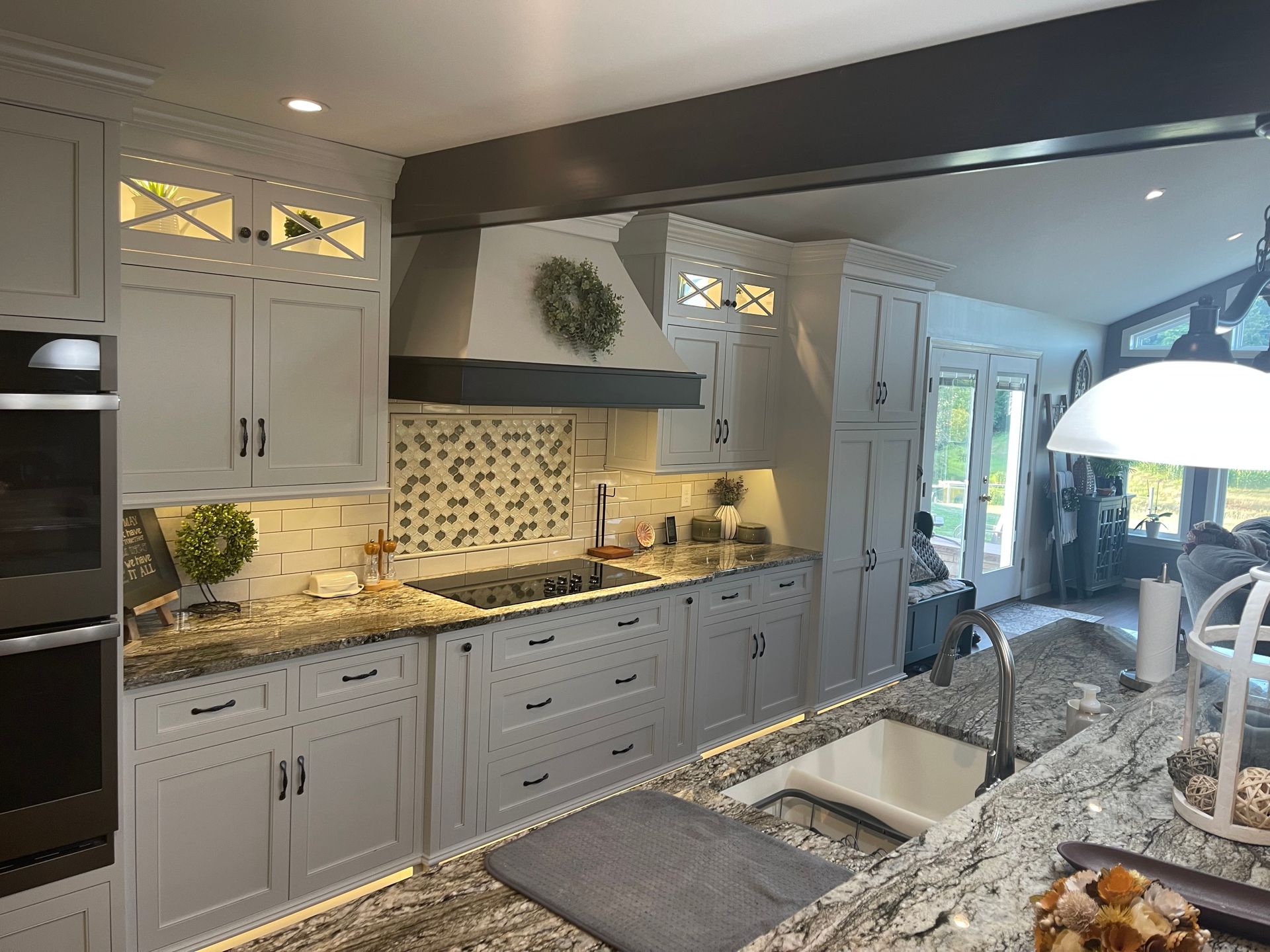 A kitchen with white cabinets , granite counter tops , a sink , and a stove.