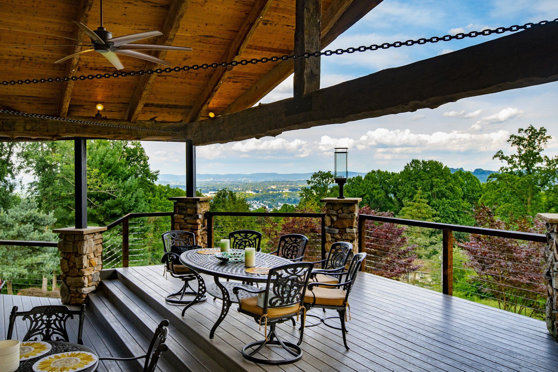 A deck with a table and chairs and a ceiling fan