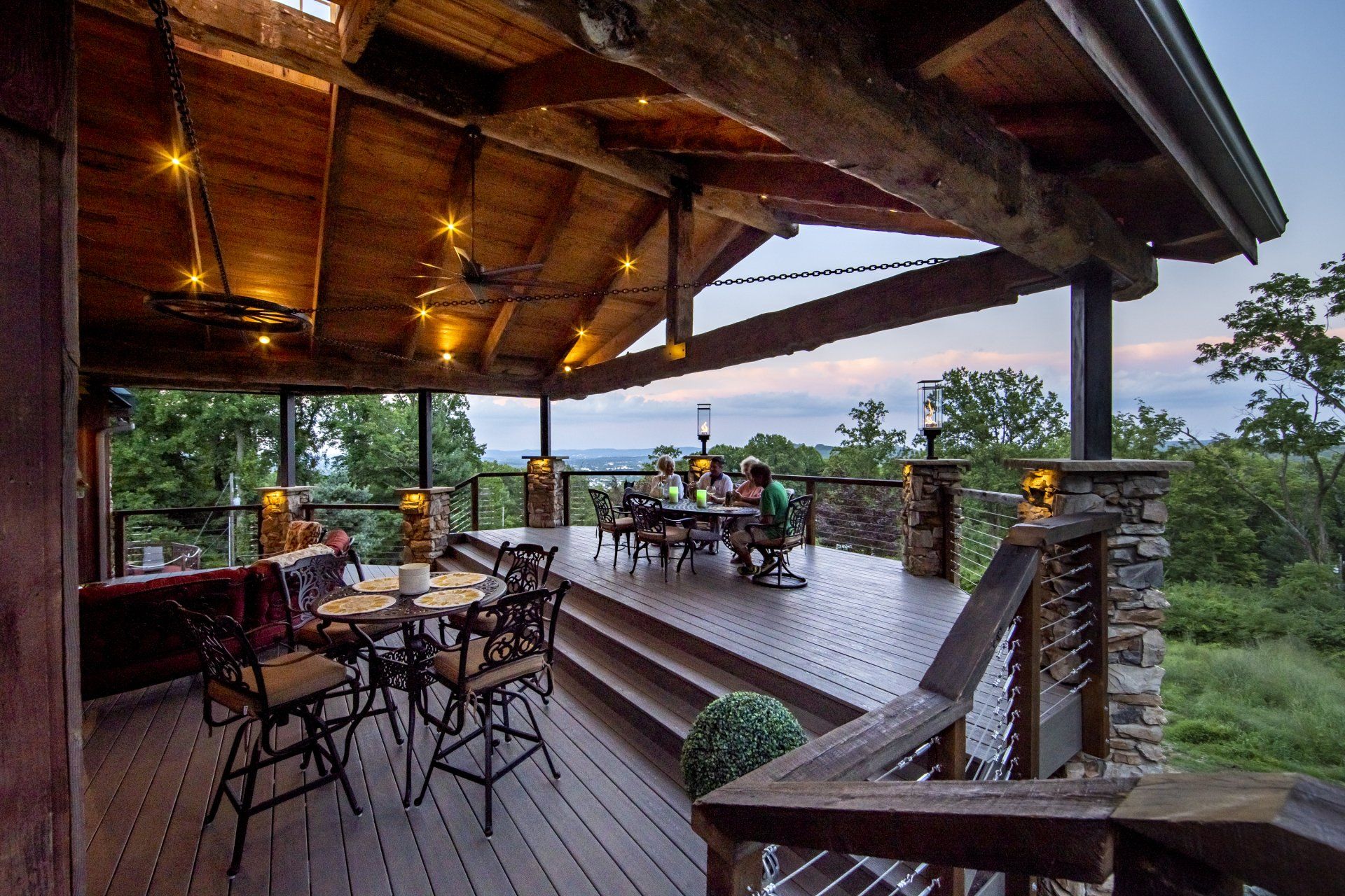 A large wooden deck with tables and chairs on it