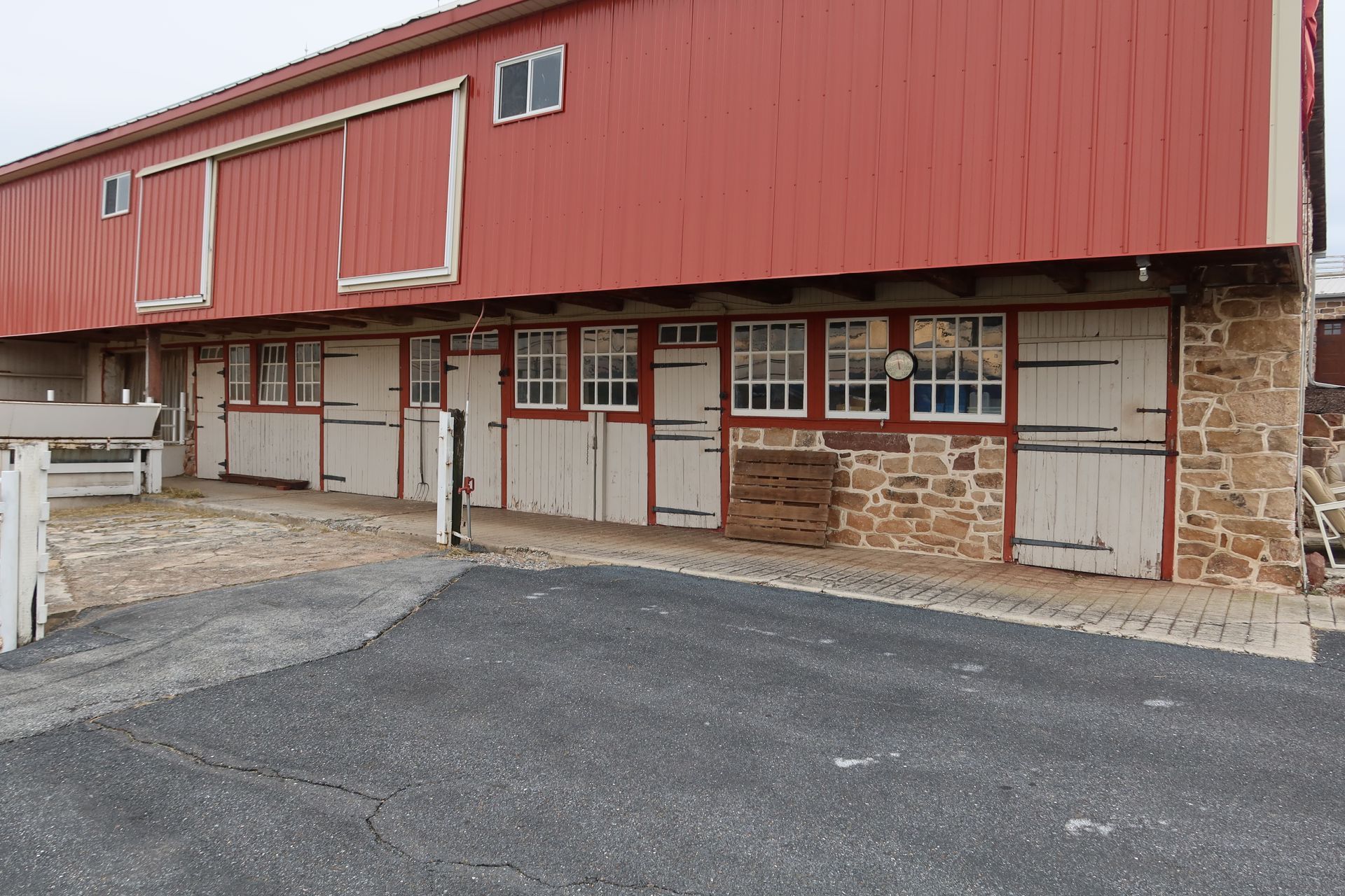 A large red barn with white doors and windows