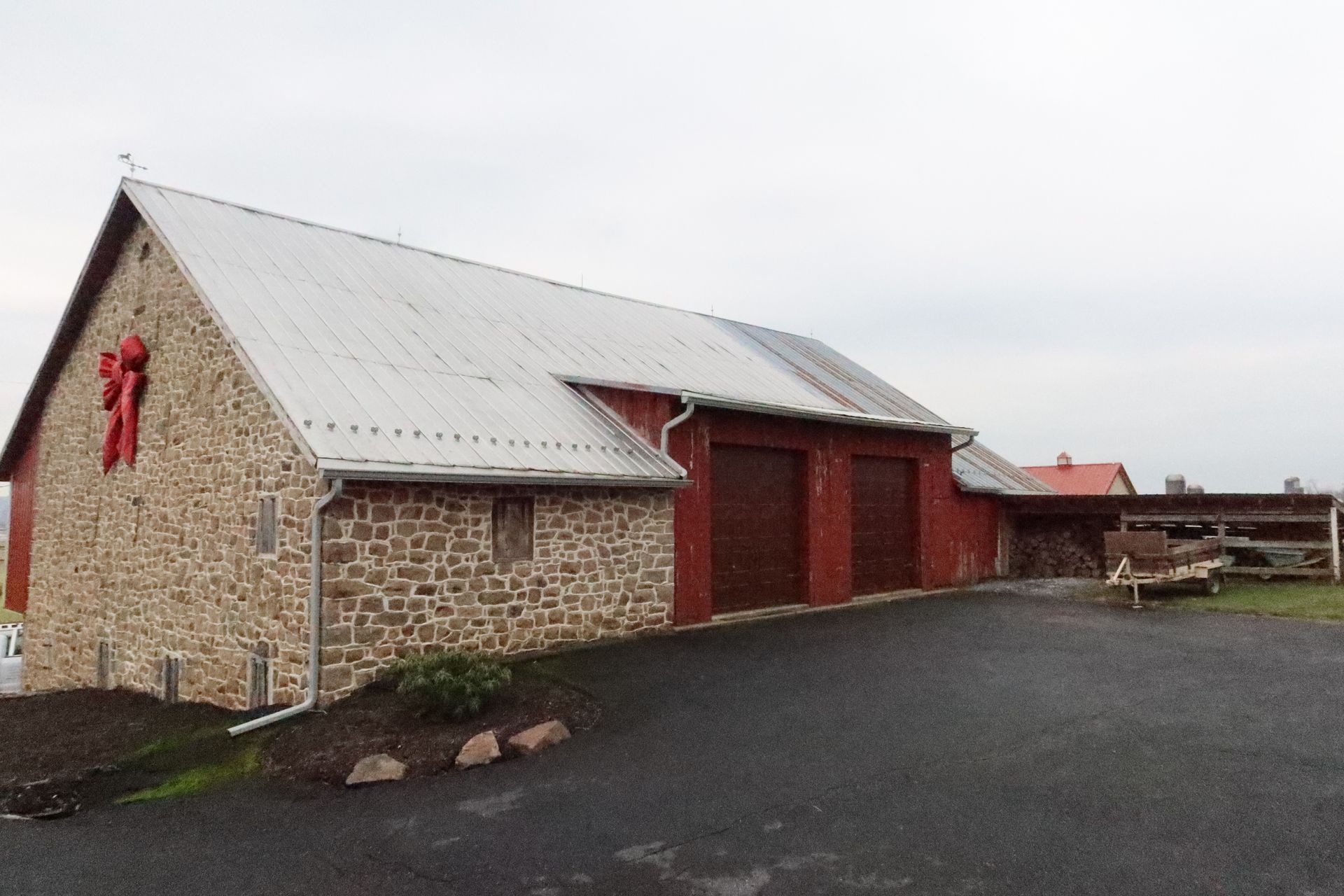 A stone building with a red door and a white roof