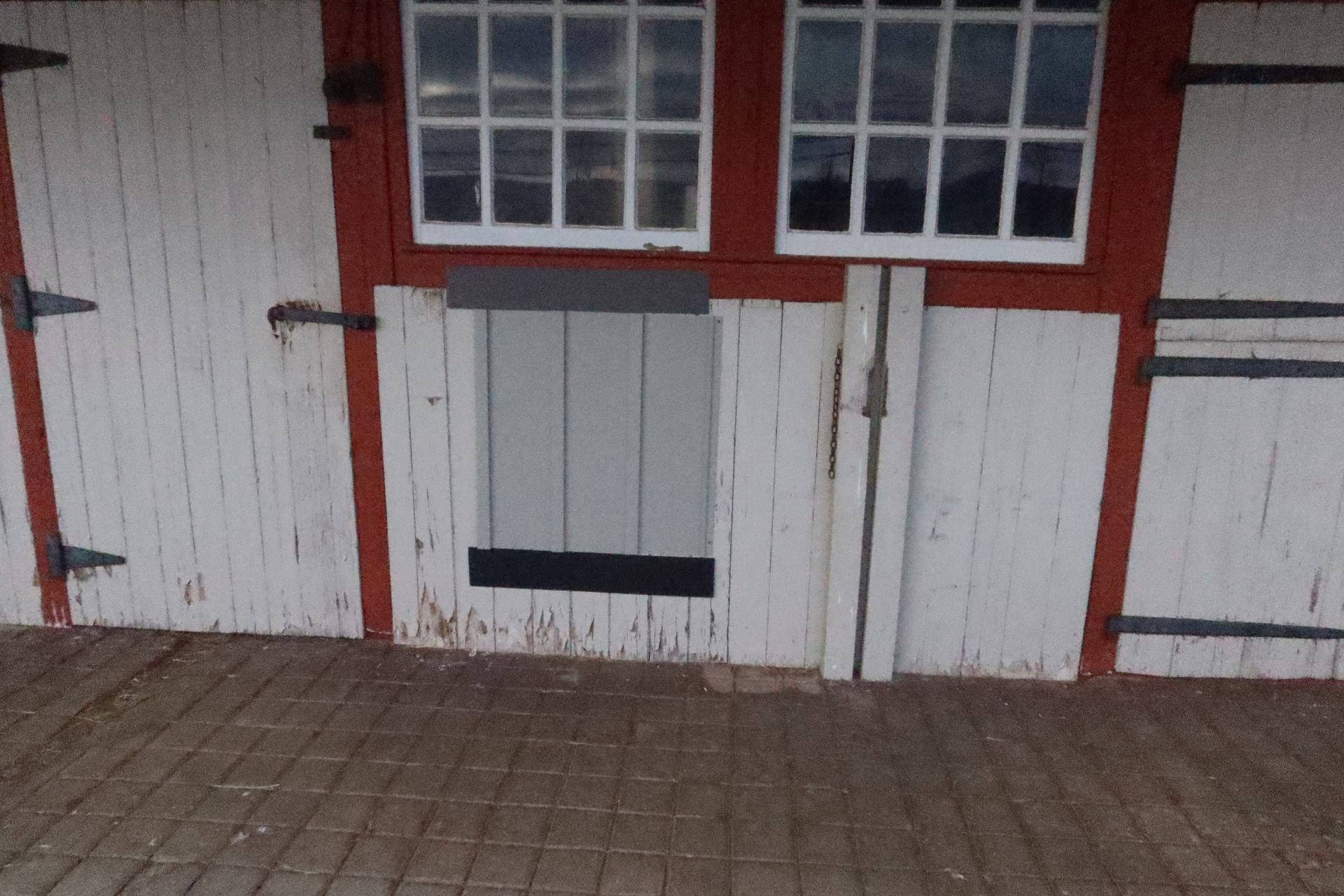 A white building with a red trim and a window