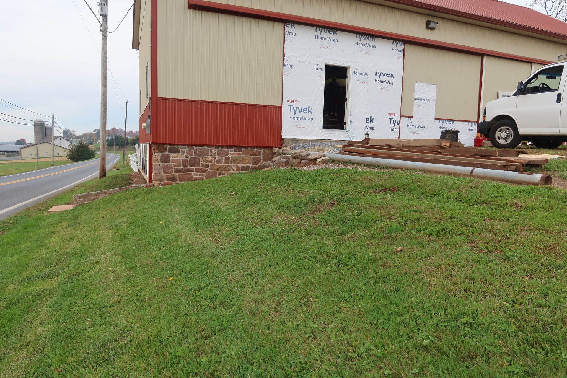 A white truck is parked in front of a building that is being remodeled.