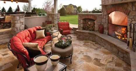 A patio with a fireplace and a couch and chairs