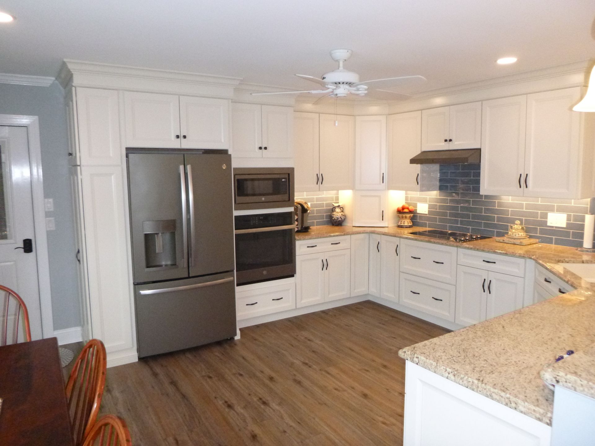 A kitchen with white cabinets and stainless steel appliances
