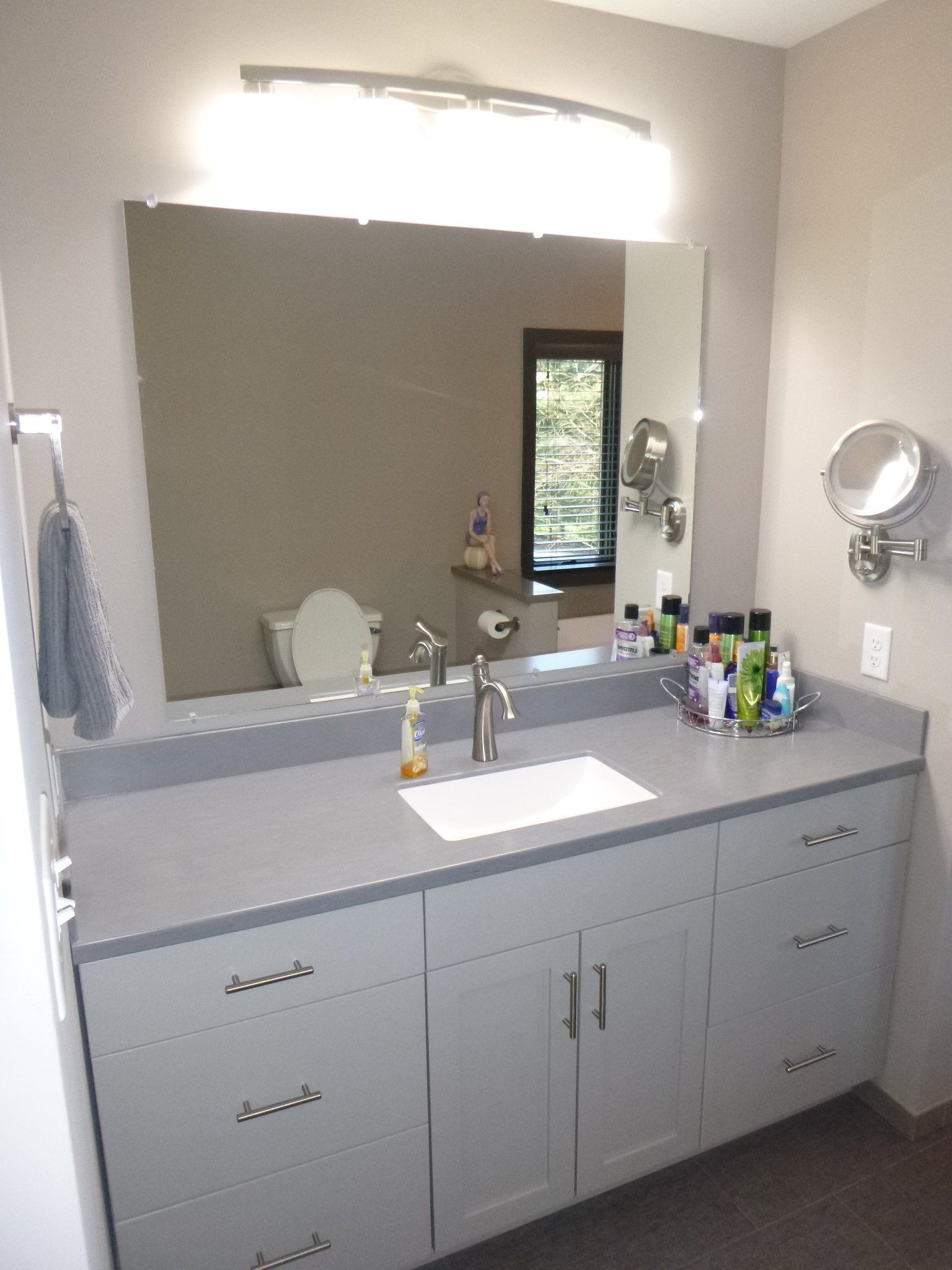 A bathroom with a sink , mirror and toilet.