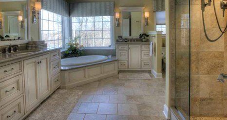 A bathroom with a tub , sink , mirror and shower.