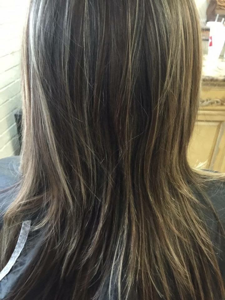 Long brown hair with blonde highlights, seen from behind in a salon setting