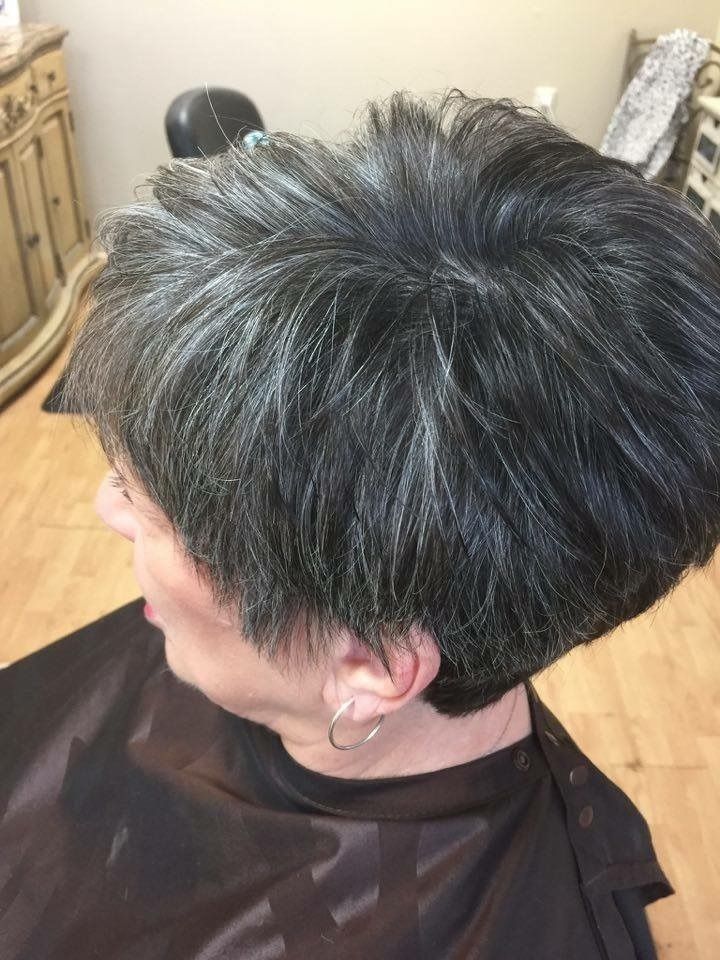 Short gray-and-black layered haircut shown in profile at a salon