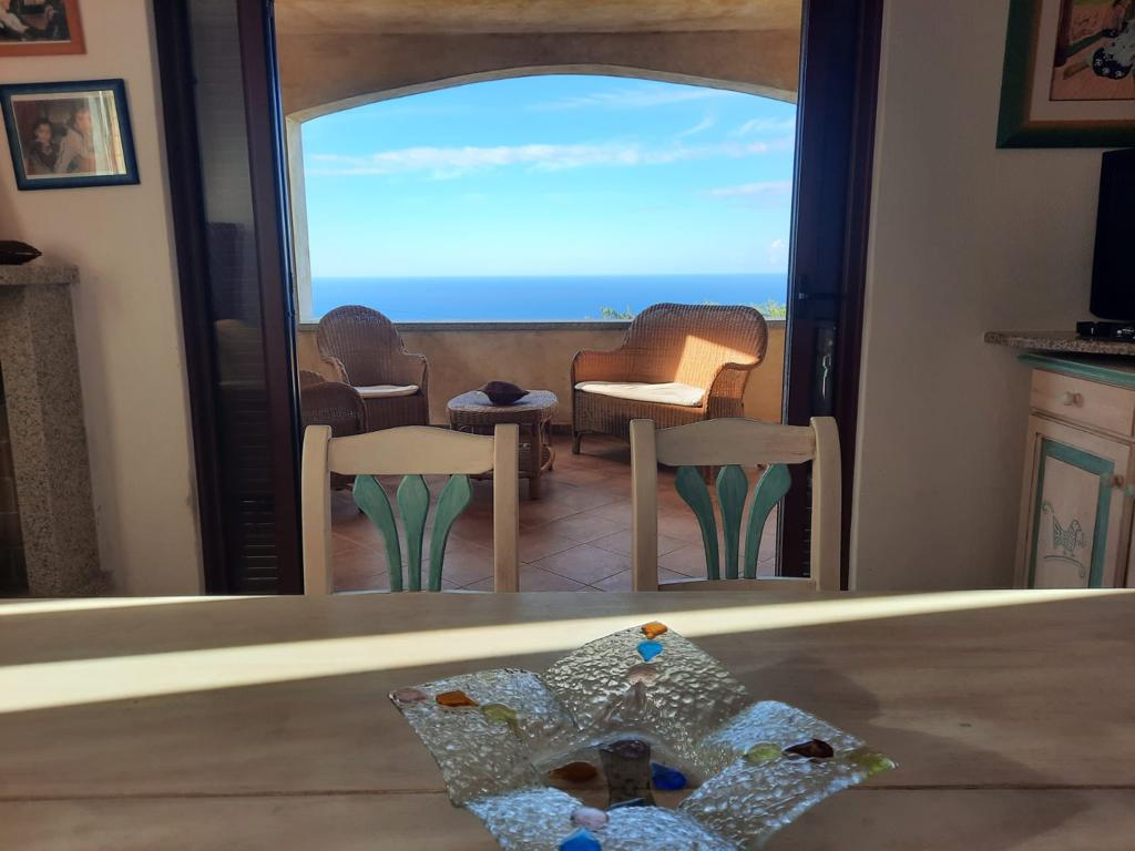 Una ciotola di vetro di mare è appoggiata su un tavolo di fronte a un balcone con vista sull'oceano