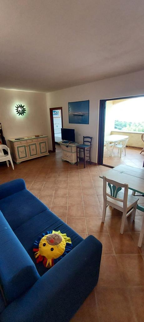 Un soggiorno con un divano blu, un tavolo e delle sedie.