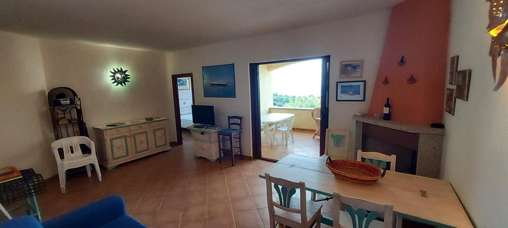 Un soggiorno con un tavolo, delle sedie e un orologio a parete.