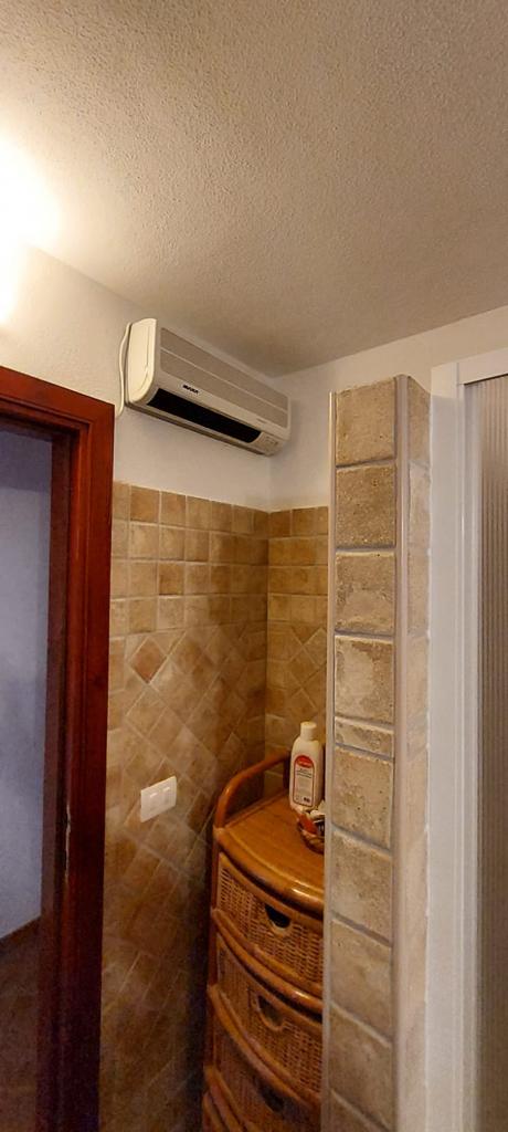 Un bagno con cassettiera e condizionatore a parete.