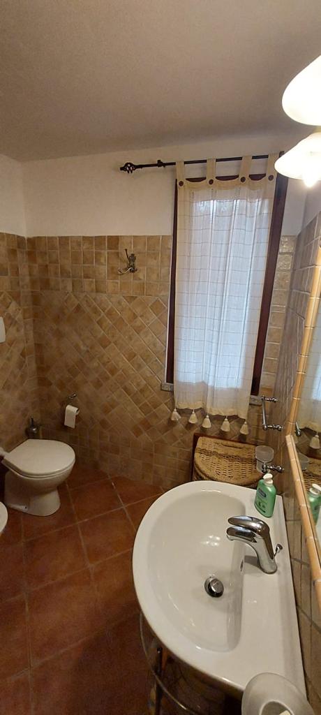 Un bagno con lavandino, water e specchio.