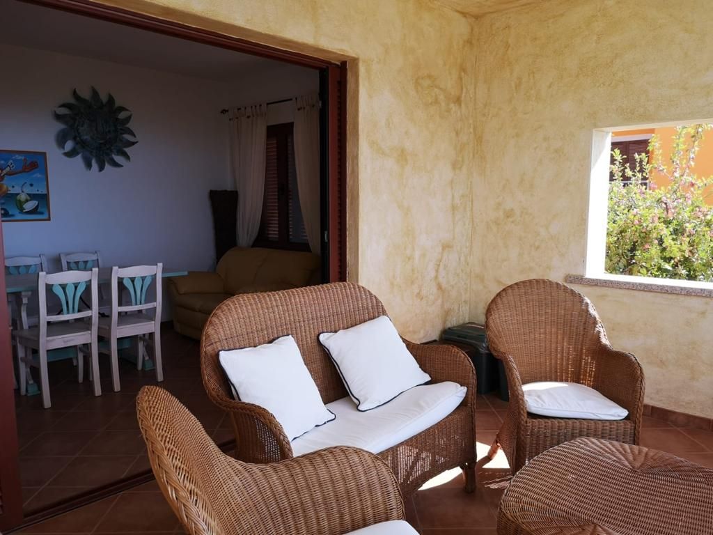 Un soggiorno con mobili in vimini e una porta scorrevole in vetro