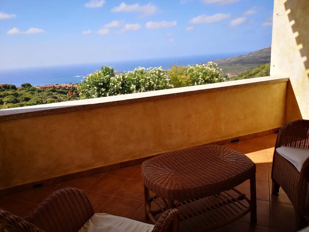 Un balcone con mobili in vimini e vista sull'oceano