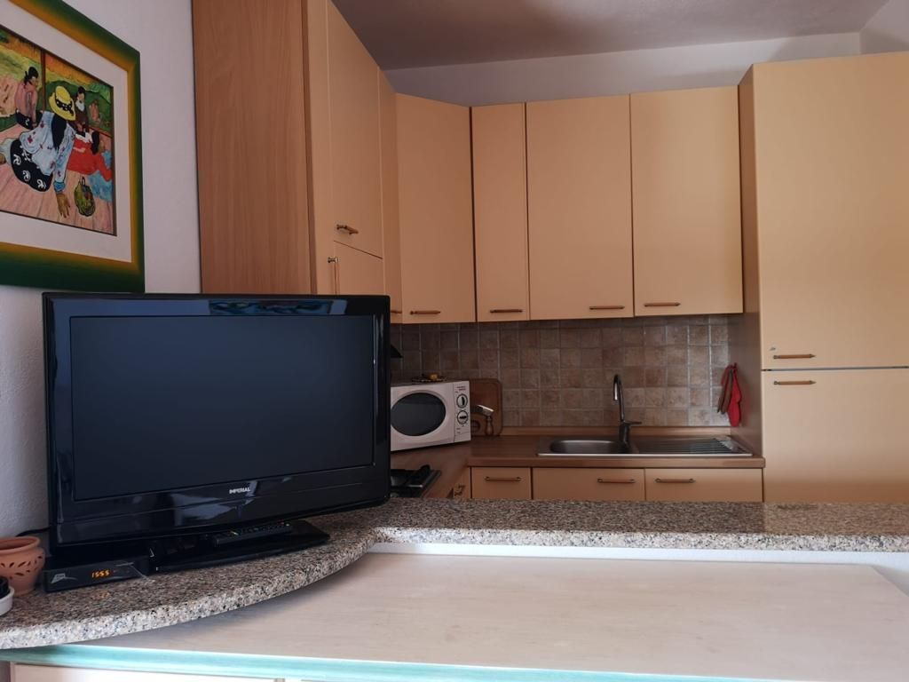 Una TV a schermo piatto è posizionata su un bancone in cucina