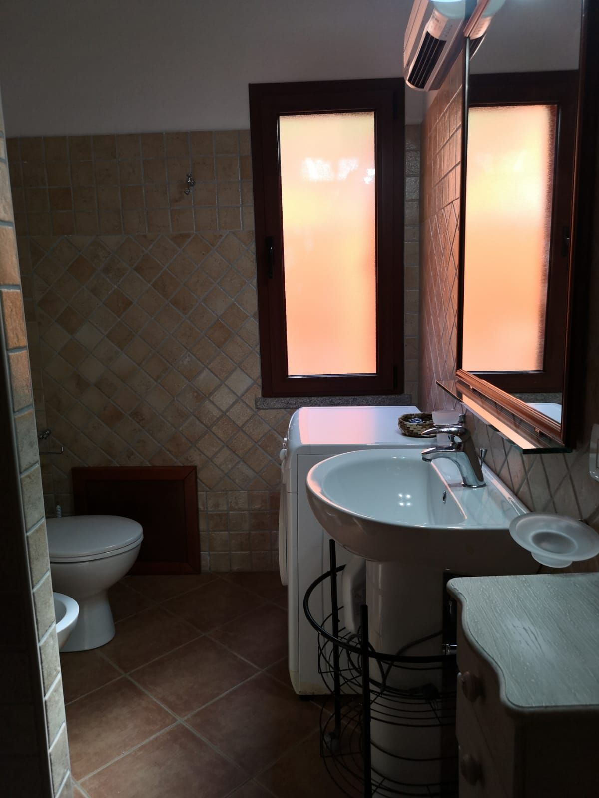 Un bagno con un water, un lavandino e uno specchio