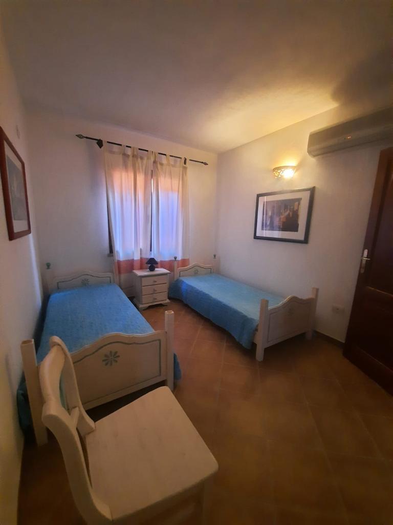 Una camera da letto con due letti e una sedia