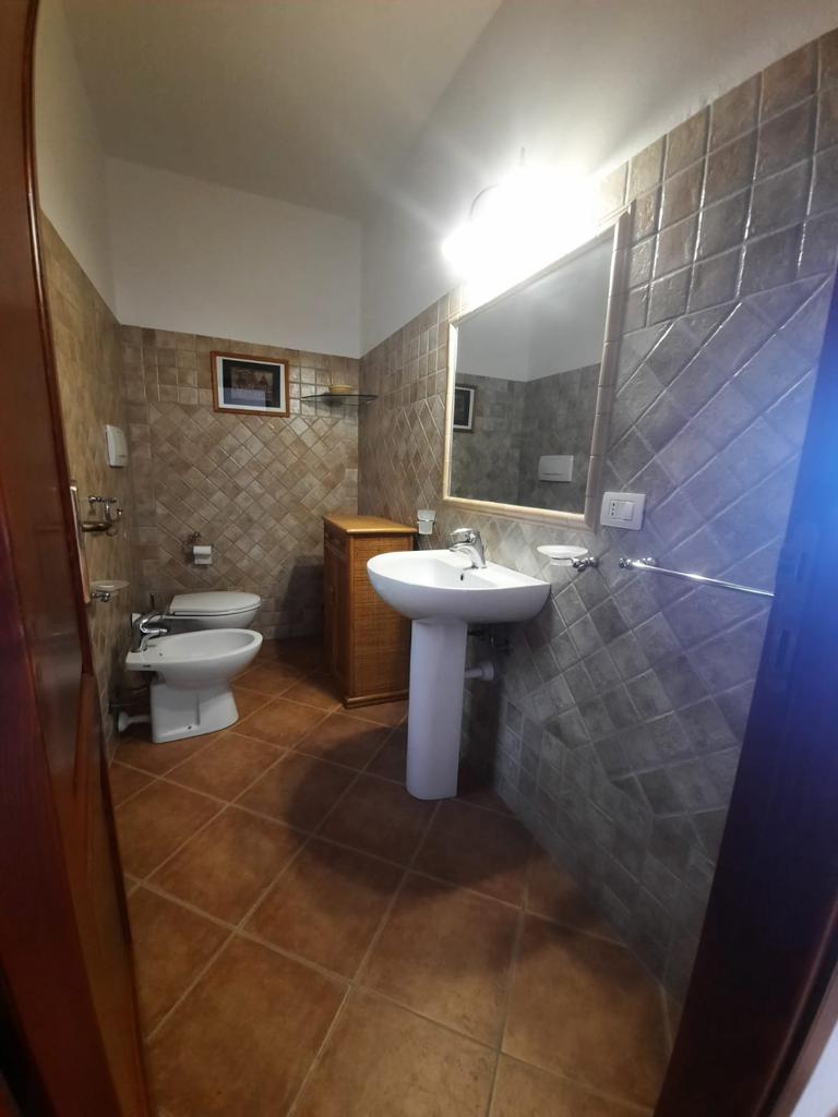 Un bagno con due water, un lavandino e uno specchio.