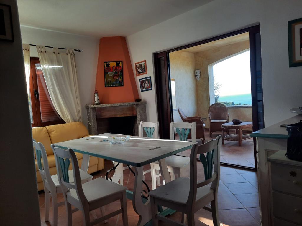 Un soggiorno con tavolo, sedie e camino