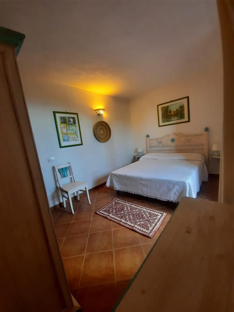 Una camera da letto con un letto, una sedia e un tappeto.