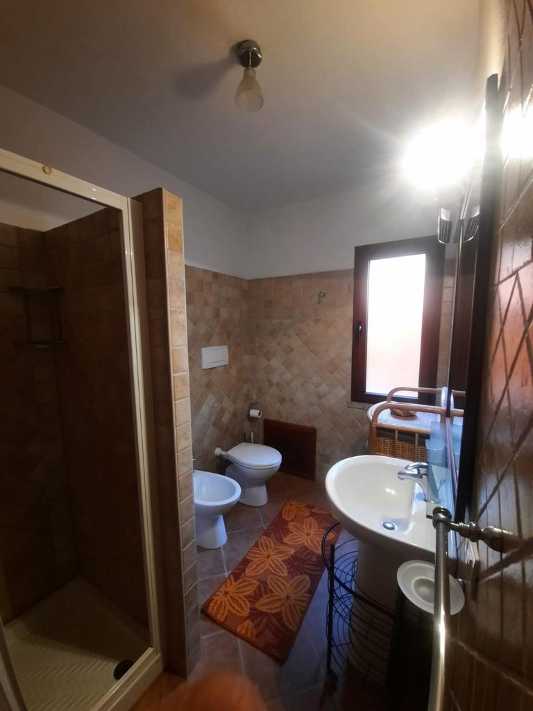 Un bagno con lavandino, WC e doccia