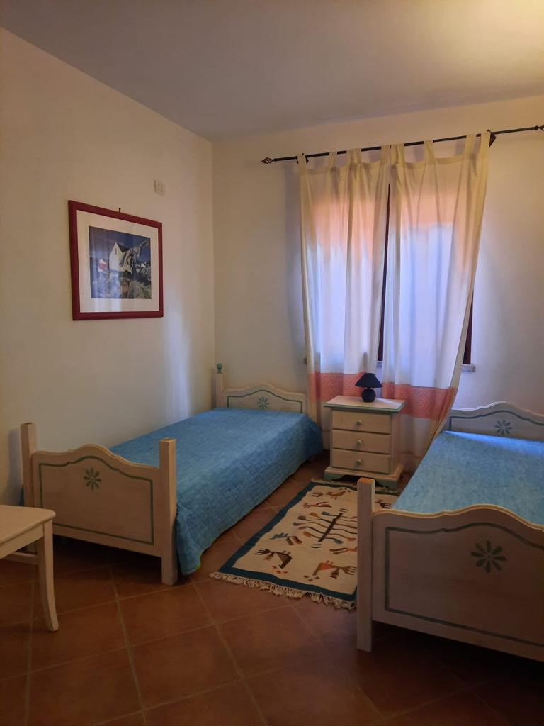 Una camera da letto con due letti e un quadro sul muro