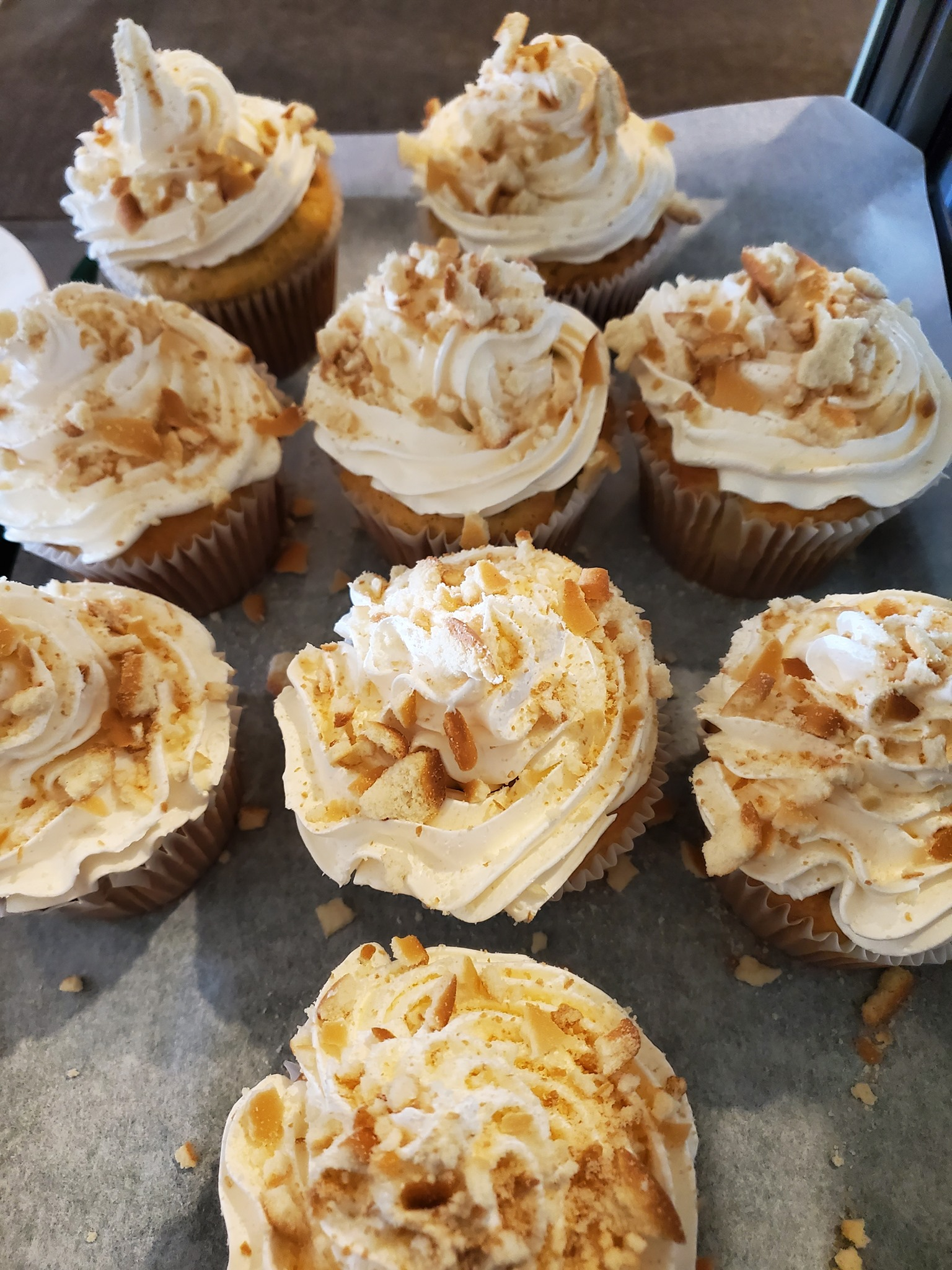 Cupcakes with white frosting and crushed cookies on top.