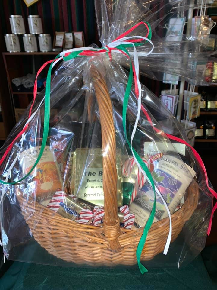 Gift basket wrapped in cellophane with red, green, and white ribbons.