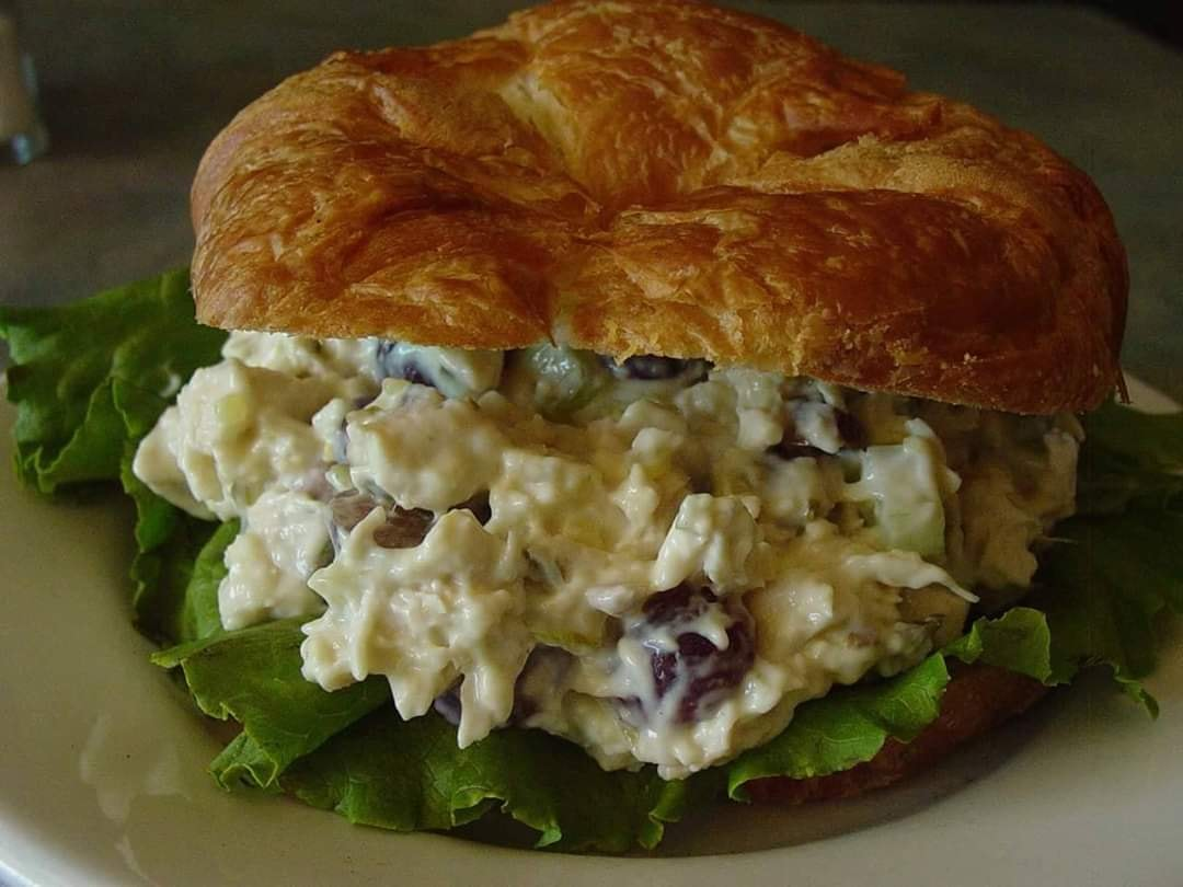 Chicken salad sandwich on croissant with lettuce.