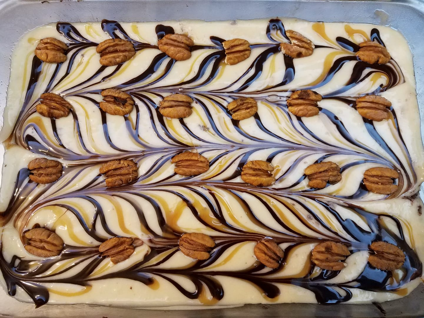 Cake with swirled chocolate, caramel, and cookies on top.