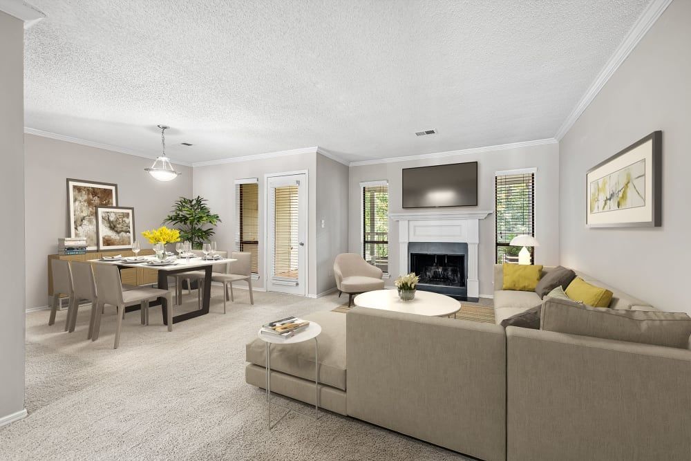Apartment living room with a couch, fireplace, dining table, and chairs at Marquis at Perimeter Center in Atlanta, GA.