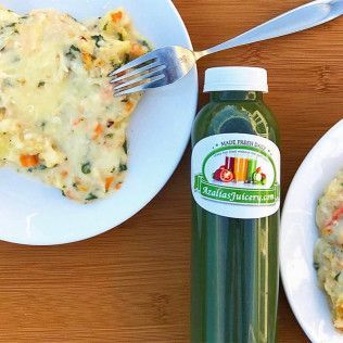 Plate of creamy food with fork beside a green bottled drink on a wooden table