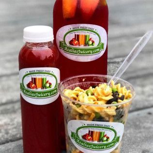 Maroon juice bottle, small jar, and salad cup with colorful pasta and vegetables on a gray surface